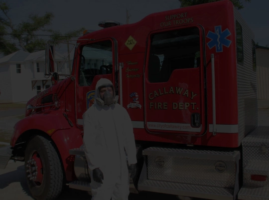 Fire truck behind a man dressed with hazard clothes